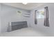 Small bedroom with grey walls, window with curtains and wall shelving at 15446 N Lakeforest Dr, Sun City, AZ 85351