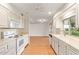 Clean kitchen with white cabinets, view to dining area at 15446 N Lakeforest Dr, Sun City, AZ 85351