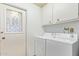 Laundry room with washer, dryer, cabinets and exterior access at 15446 N Lakeforest Dr, Sun City, AZ 85351