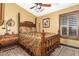 Charming bedroom with a large wooden bed and window shutters at 20811 E Excelsior Ave, Queen Creek, AZ 85142