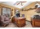 Functional home office with a large desk, comfortable chair, and built-in shelving at 20811 E Excelsior Ave, Queen Creek, AZ 85142