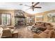 Living room with stone fireplace, large windows and ceiling fan at 20811 E Excelsior Ave, Queen Creek, AZ 85142