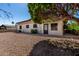 Exterior view showcasing a gravel backyard, mature landscaping, and the back of the home at 2233 N Middlecoff Dr, Mesa, AZ 85215