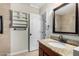Updated bathroom with granite countertops, modern mirror, and convenient storage shelves at 2233 N Middlecoff Dr, Mesa, AZ 85215