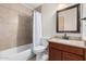 Bathroom featuring a vanity, mirror, toilet and a shower-tub combo, showcasing a functional and modern design at 2233 N Middlecoff Dr, Mesa, AZ 85215