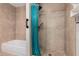 Bathroom featuring a tiled shower, showerhead, and a turquoise shower curtain, showcasing a clean and modern design at 2233 N Middlecoff Dr, Mesa, AZ 85215