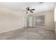 Comfortable bedroom featuring neutral carpeting, ceiling fan, and sliding glass door access at 2233 N Middlecoff Dr, Mesa, AZ 85215