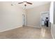 Bright bedroom featuring neutral walls, tile floors, a ceiling fan, and a view of a laundry area at 2233 N Middlecoff Dr, Mesa, AZ 85215