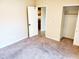 Neutral carpeted bedroom featuring a closet and adjoining room with tile floor at 2233 N Middlecoff Dr, Mesa, AZ 85215