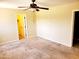 Spacious bedroom featuring plush carpet, ceiling fan, and walk-in closet entrance at 2233 N Middlecoff Dr, Mesa, AZ 85215