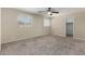 Spacious bedroom with plush carpeting, ceiling fan, and windows for natural light at 2233 N Middlecoff Dr, Mesa, AZ 85215