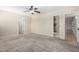 Bright bedroom with neutral carpeting, ceiling fan, and access to en-suite bathroom and closet at 2233 N Middlecoff Dr, Mesa, AZ 85215