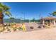 Landscaped community entrance with tennis courts, palm trees, guard house, and desert flora on a sunny day at 2233 N Middlecoff Dr, Mesa, AZ 85215
