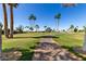 Pathway through the golf course, surrounded by green grass and palm trees at 2233 N Middlecoff Dr, Mesa, AZ 85215
