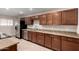 Renovated kitchen showcasing wooden cabinetry, granite countertops, and stainless steel appliances at 2233 N Middlecoff Dr, Mesa, AZ 85215