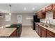 Well-lit kitchen with granite countertops, stainless steel appliances, tile flooring, and dining area at 2233 N Middlecoff Dr, Mesa, AZ 85215