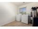 Functional laundry room with essential appliances, a window for natural light, and storage at 2233 N Middlecoff Dr, Mesa, AZ 85215