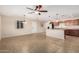 Bright and airy open floor plan with tile flooring, ceiling fan, and seamless flow into the kitchen at 2233 N Middlecoff Dr, Mesa, AZ 85215