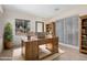 Home office featuring rustic wood desk, built in bookcase, and bright windows at 2233 N Middlecoff Dr, Mesa, AZ 85215