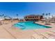 Large community pool surrounded by lounge chairs and palm trees, offering residents a relaxing outdoor space at 2233 N Middlecoff Dr, Mesa, AZ 85215