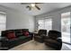 Living room with leather couches and access to backyard at 22525 W Antelope Trl, Buckeye, AZ 85326