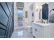 Modern bathroom with white vanity, black accents, and a view of the pool at 23807 N 64Th Ave, Glendale, AZ 85310