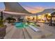 Inviting backyard oasis with a freeform pool, shaded patio, and stunning sunset views at 23807 N 64Th Ave, Glendale, AZ 85310