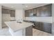 Modern kitchen island featuring a sink, gray cabinets, and a sleek design at 24177 W Hilton Ave, Buckeye, AZ 85326