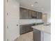 Well-lit kitchen with gray cabinetry, white backsplash, and stainless steel appliances at 24177 W Hilton Ave, Buckeye, AZ 85326