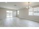 Well-lit living room with wood-look floors, large windows, and access to the patio at 24177 W Hilton Ave, Buckeye, AZ 85326