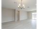 Bright living room with wood-look floors, a modern chandelier, and abundant natural light at 24177 W Hilton Ave, Buckeye, AZ 85326