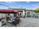 Relaxing backyard patio with fire pit and seating area under umbrella at 3525 E Robin Ln, Phoenix, AZ 85050