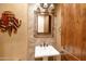 Elegant powder room with a pedestal sink, decorative mirror, and tile backsplash at 3525 E Robin Ln, Phoenix, AZ 85050