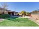 Landscaped backyard with artificial turf, fire pit, and patio at 42034 N Harbour Town Ct, Anthem, AZ 85086
