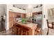 Bright kitchen featuring an island with tiled countertop and wood cabinetry at 4293 S Columbine Way, Gold Canyon, AZ 85118