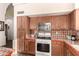 View of kitchen with wood cabinets, tiled backsplash and gas range at 4293 S Columbine Way, Gold Canyon, AZ 85118