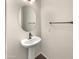 Small powder room with pedestal sink and oval mirror at 4738 E Tierra Buena Ln, Phoenix, AZ 85032