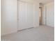 An empty bedroom with neutral carpet featuring a closet with sliding doors at 11029 E Ulysses Ave, Mesa, AZ 85212