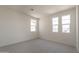A bright, empty bedroom is seen, showcasing neutral carpet and multiple large windows at 11029 E Ulysses Ave, Mesa, AZ 85212