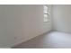 A bright bedroom with light gray carpet and a single window at 11029 E Ulysses Ave, Mesa, AZ 85212