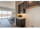 Butler pantry with dark cabinets, white countertop, decorative backsplash, and view to the dining and living areas at 11029 E Ulysses Ave, Mesa, AZ 85212