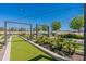 Inviting common area with turf lawn, decorative landscaping, pergola and string lights perfect for outdoor enjoyment at 11029 E Ulysses Ave, Mesa, AZ 85212