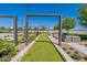 Inviting common area with turf lawn, decorative landscaping, pergola and string lights perfect for outdoor enjoyment at 11029 E Ulysses Ave, Mesa, AZ 85212