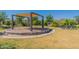 Shaded common area with seating and fire pit, overlooking green spaces and landscaping at 11029 E Ulysses Ave, Mesa, AZ 85212