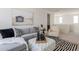 Upstairs living room features a gray sofa, white ottoman, black-and-white rug, and serene wall art at 11029 E Ulysses Ave, Mesa, AZ 85212
