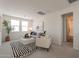 Upstairs living room features a gray sofa, white ottoman, black-and-white rug, and three windows at 11029 E Ulysses Ave, Mesa, AZ 85212