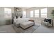 Bright main bedroom features a tufted headboard, bench, neutral palette, and an abundance of natural light at 11029 E Ulysses Ave, Mesa, AZ 85212