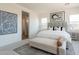 Bright main bedroom with a tufted headboard, bench, neutral color palette, and ensuite bath visible in the background at 11029 E Ulysses Ave, Mesa, AZ 85212