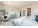 Bright main bedroom with a tufted headboard, neutral color palette, bench, and ensuite bath visible in the background at 11029 E Ulysses Ave, Mesa, AZ 85212