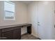 Spacious mud room with built-in desk, storage cabinets, and a window for natural light at 11029 E Ulysses Ave, Mesa, AZ 85212